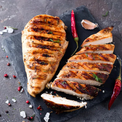 Fresh free-range chicken breast fillets from Primrose Herd, showing raw, boneless, skinless chicken breasts on a white surface.
