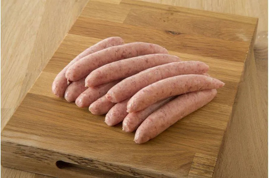 Primrose Herd Cornish outdoor-reared pork sage and onion chipolatas sausages on a plate, ready for cooking.
