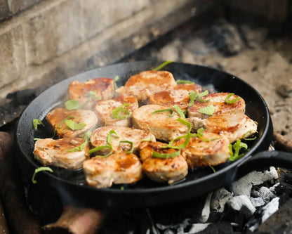 Primrose Herd pork tenderloin medallions, cut into steaks, fresh and uncooked, showcasing juicy, tender pork slices on a white surface.