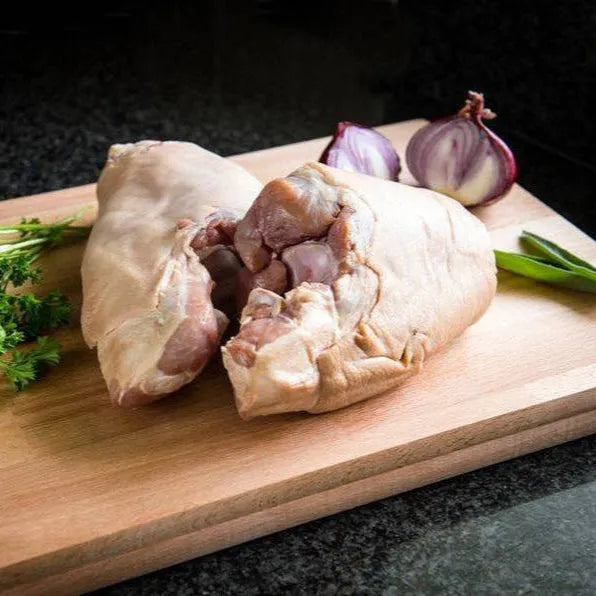 Smoked ham hocks from Primrose Herd, showing sliced and whole ham pieces with a rich, smoky appearance on a wooden surface.