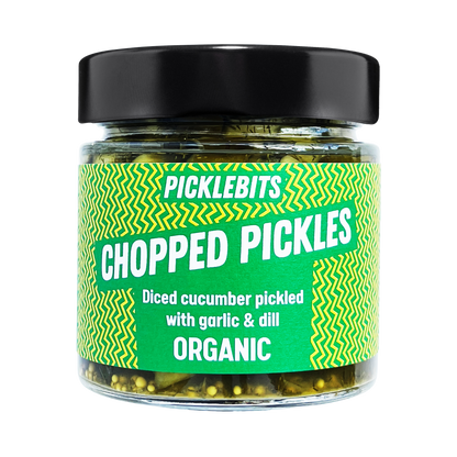 Organic chopped dill pickles by PICKLEBITS in a jar, showing fresh cucumber pieces with dill herbs and a tangy pickle liquid.