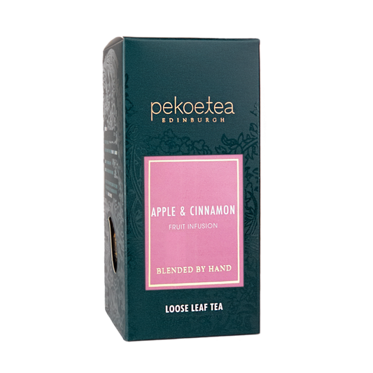 Loose leaf apple and cinnamon fruit infusion tea by PekoeTea Edinburgh in a box, showcasing dried fruit and tea leaves.