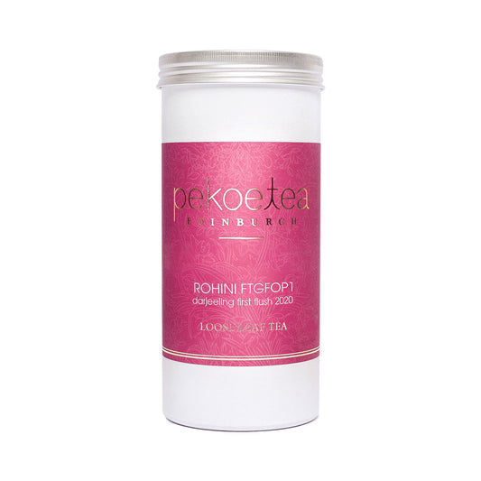 PekoeTea Edinburgh Rohini 2023 First Flush Darjeeling tea caddy with green tea leaves and packaging.