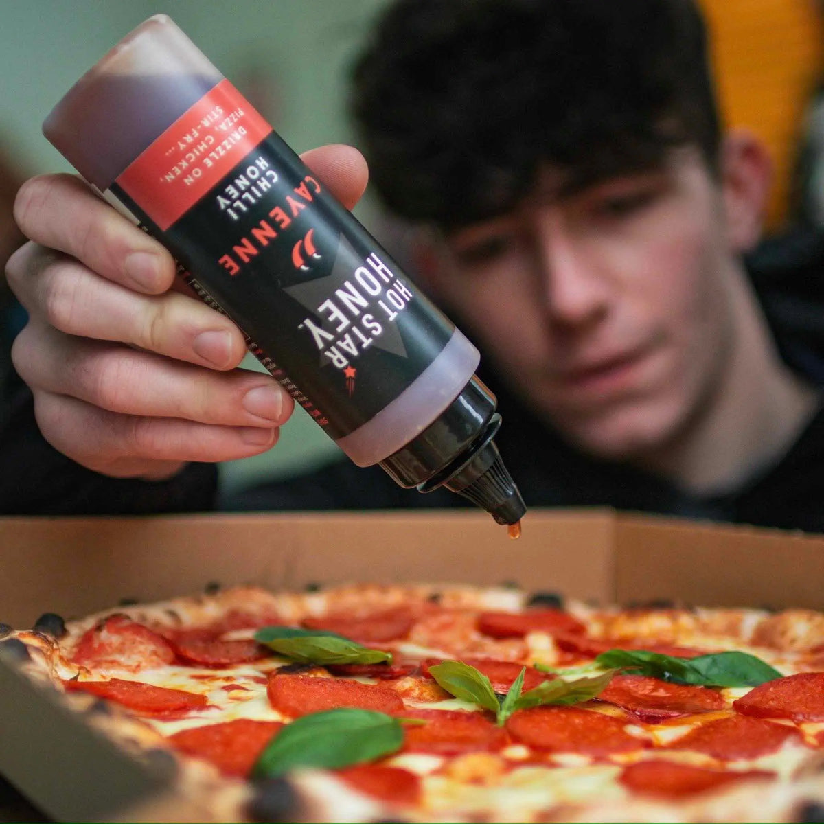 Spicy chili honey drizzled on a pizza, showcasing the Hot Star Honey Chilli Honey Set with cayenne pepper flavor.