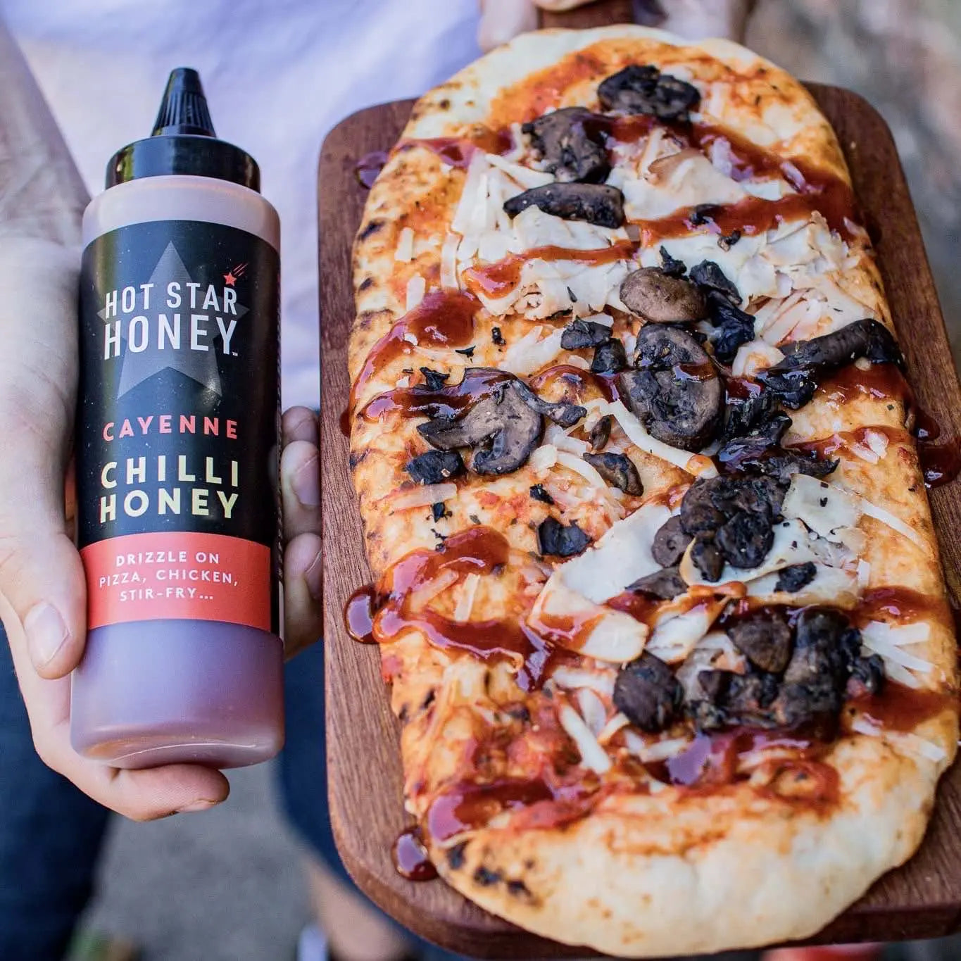 Hot Star Honey cayenne chili honey spread on pizza, showing a drizzle of spicy honey topping with melted cheese.