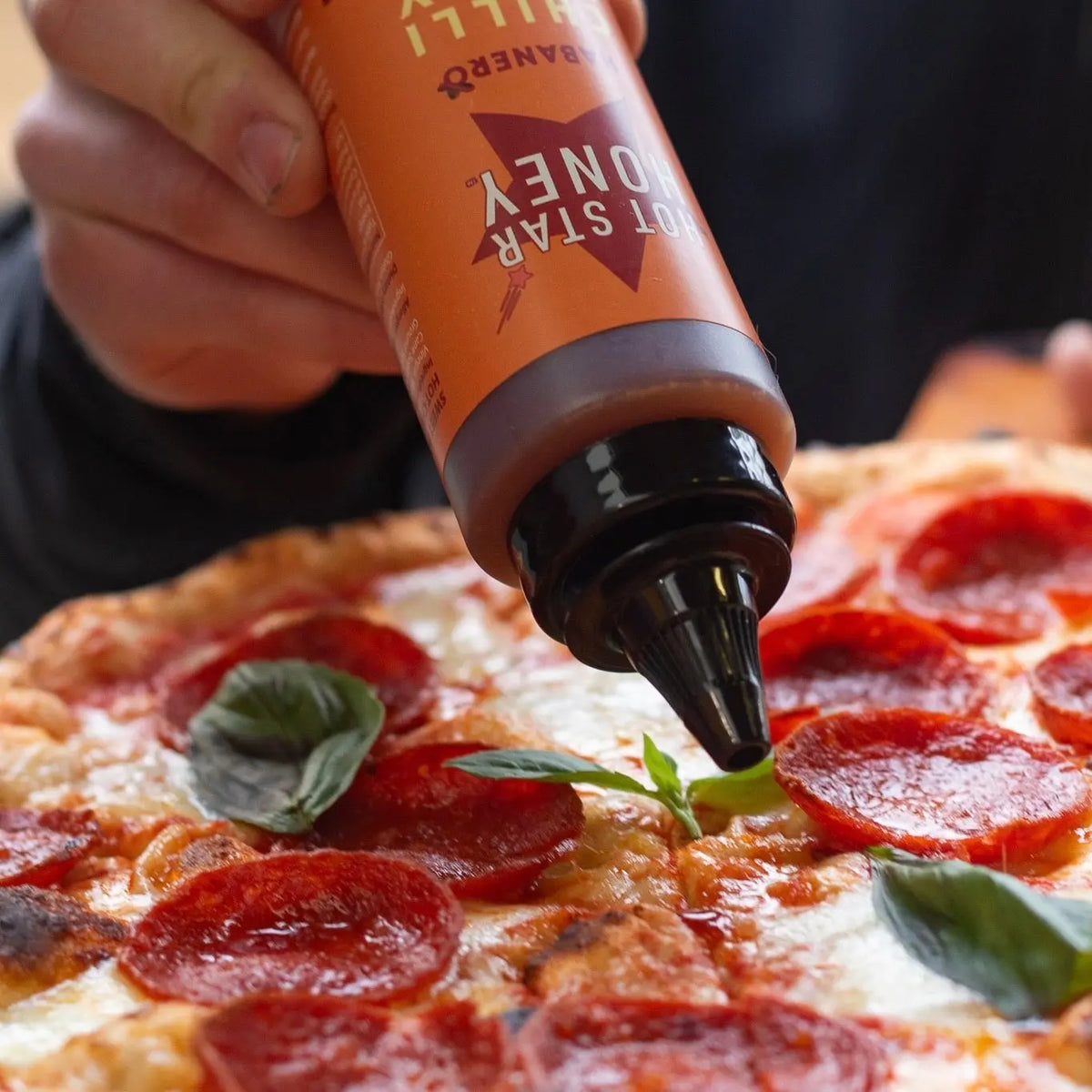 Habanero hot chilli honey drizzle on pizza showing bright orange habanero peppers and golden honey topping.