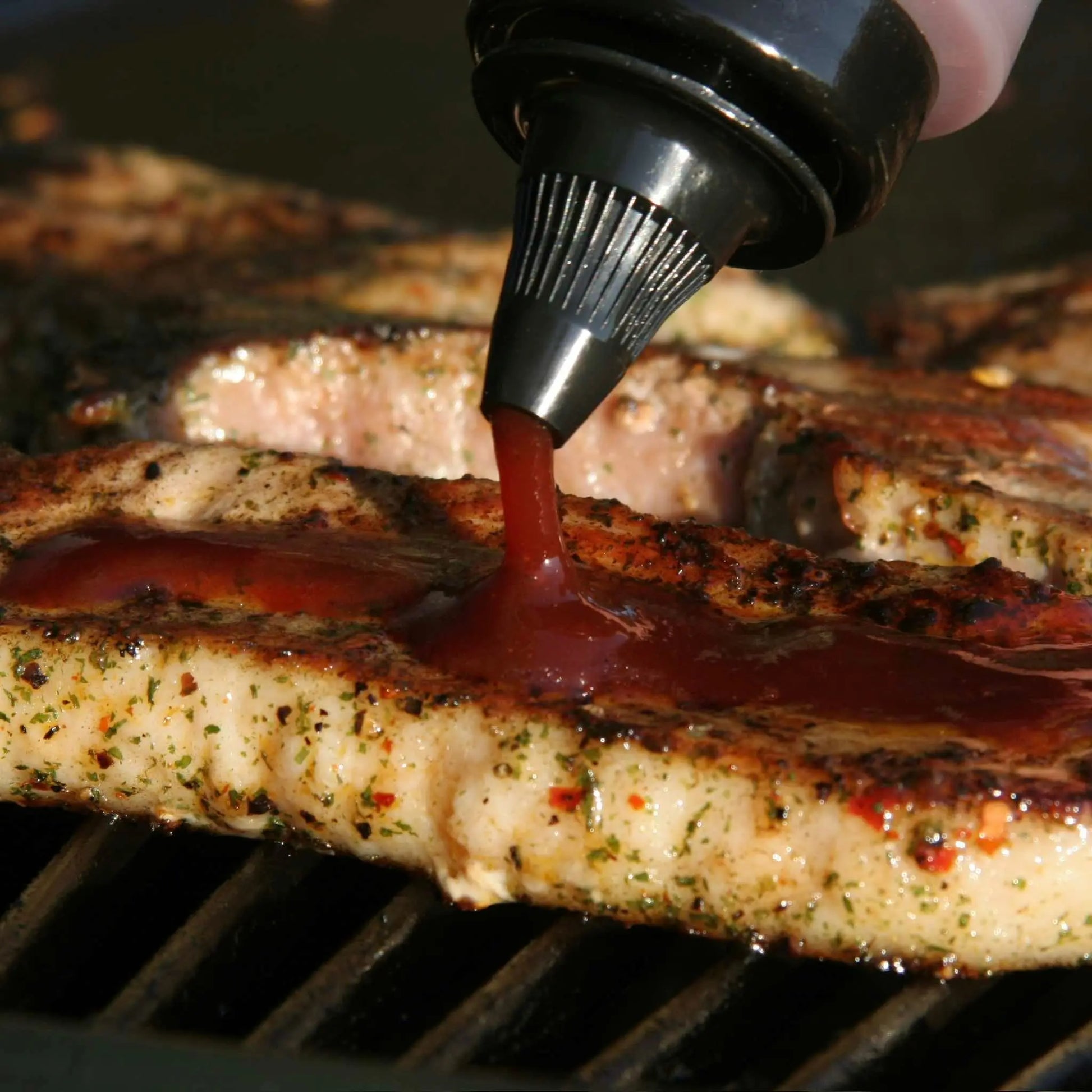 Korean BBQ honey sauce from Hot Star Honey drizzled over grilled steak, showcasing glossy, caramelized meat with sauce.