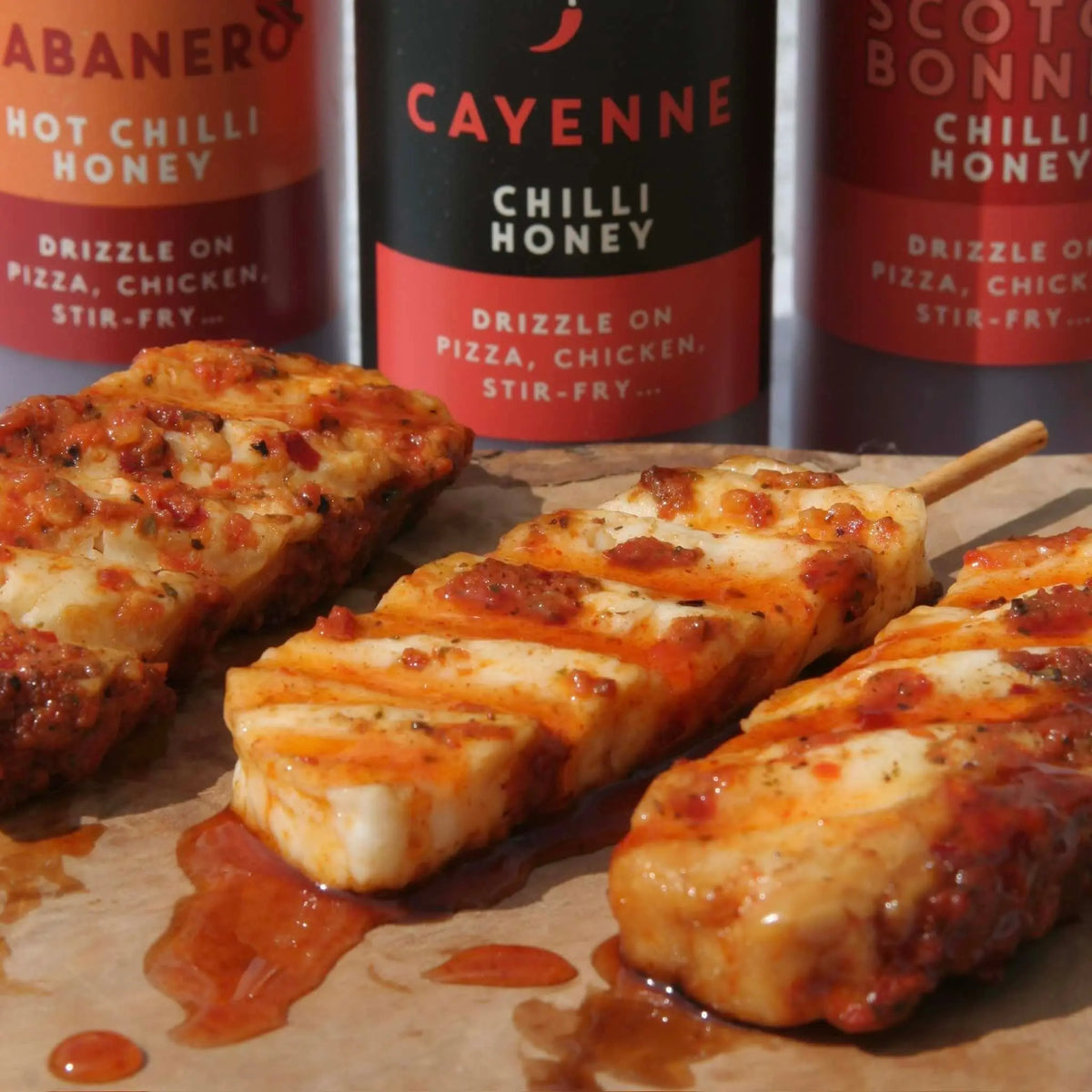Hot Star Honey chilli honey set with cayenne pepper drizzle on halloumi cheese, showcasing spicy-sweet flavor.
