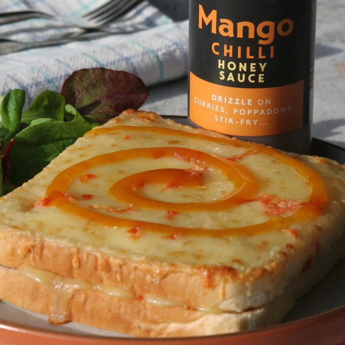 Mango chilli honey sauce from Hot Star Honey drizzled over toasted bread, showcasing a vibrant Asian-inspired condiment.