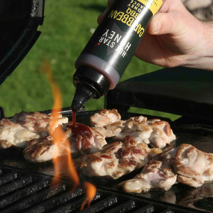 Hot Star Honey Caribbean BBQ Sauce poured over grilled chicken, showcasing a rich, flavorful honey-based barbecue sauce.