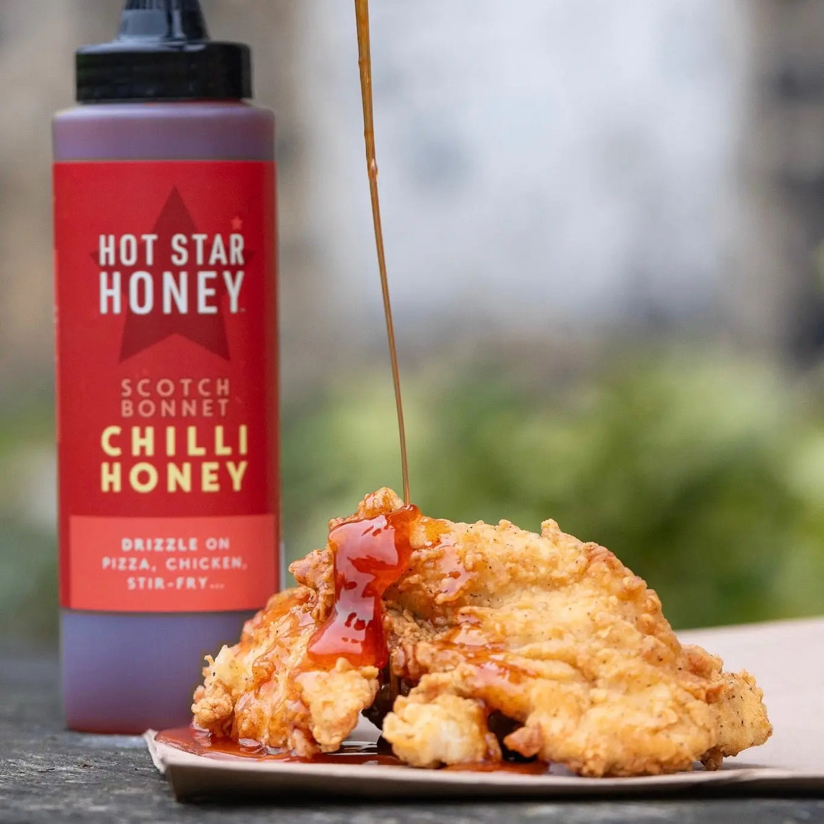 Hot Star Honey chilli honey set with a spoon and chicken, showcasing the spicy-sweet flavor of the Chilli Honey product.
