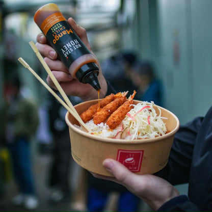 Asian-inspired Hot Star Honey Mango Chilli Honey Sauce drizzled over a dish with fresh mango and vibrant chili peppers.