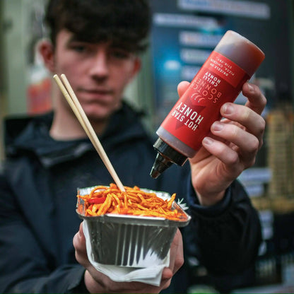 Hot Star Honey Scotch Bonnet Chilli Honey drizzled over stir-fry, showcasing a spicy-sweet glaze with visible chili peppers and honey.