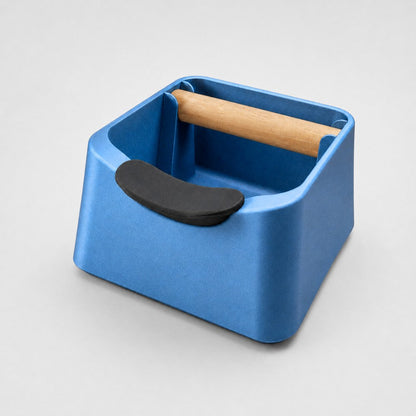 KNOCDIC® The Pod 3-in-1 Espresso Knock Box with metallic blue finish, portafilter stand, and oak wood knock bar for coffee grounds.