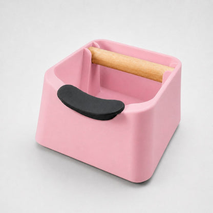Pink KNOCDIC® Pod 3-in-1 espresso knock box with portafilter stand and oak wood knock bar for coffee grounds cleanup.
