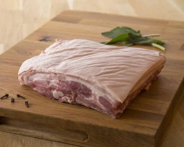 Primrose Herd pork belly on the bone, showcasing juicy, flavorful pork belly with crispy skin and tender meat.