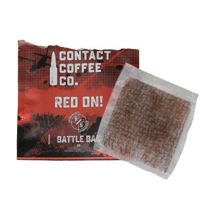 Red single-serve coffee brew bag from Contact Coffee Company Ltd., ready for brewing in a coffee cup.