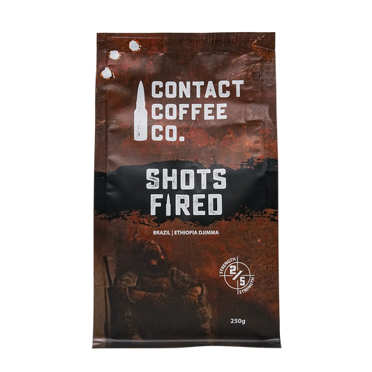 ArtisanBox Shots Fired Coffee bag with bold label design, showcasing premium roasted coffee beans and branding.
