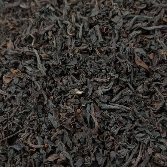 Santosa BOPS black tea leaves from Porter Hill Tea Company in a clear glass jar, showcasing dark, whole tea leaves.