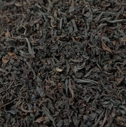Santosa BOPS black tea leaves from Porter Hill Tea Company in a clear glass jar, showcasing dark, whole tea leaves.