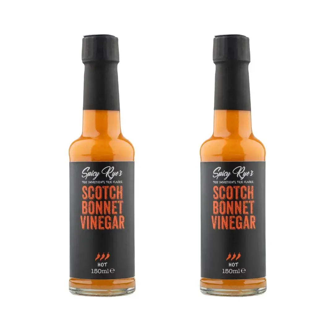 Two bottles of Spicy Ryes Scotch Bonnet Vinegar with red caps and labels, showcasing the spicy vinegar product.