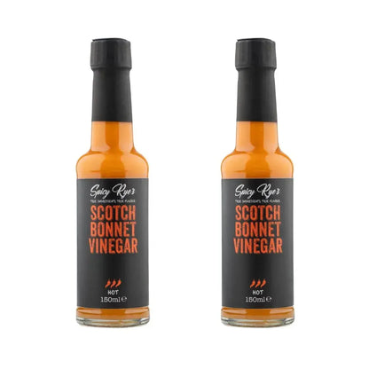 Two bottles of Spicy Ryes Scotch Bonnet Vinegar with red caps and labels, showcasing the spicy vinegar product.