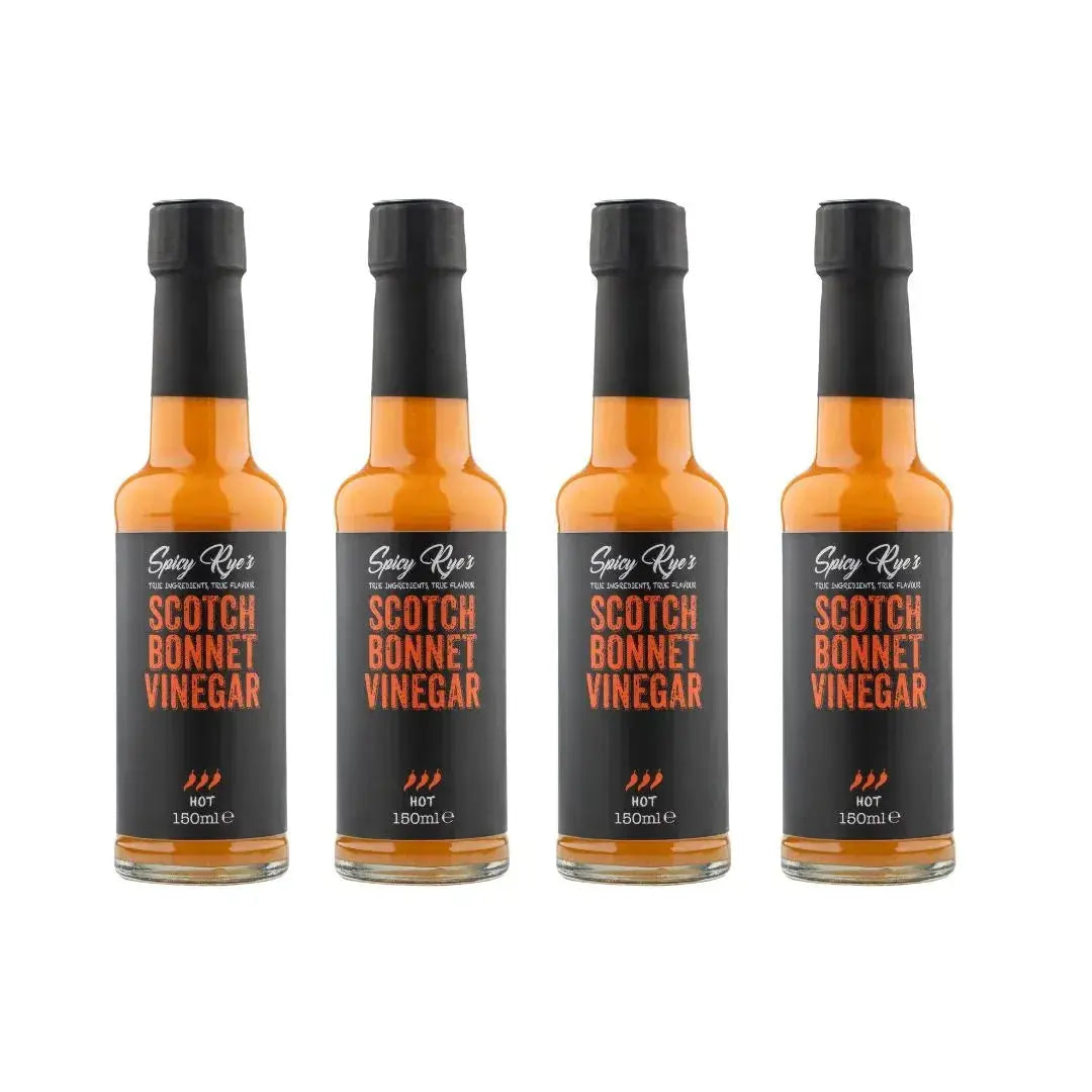 Four bottles of Spicy Ryes Scotch Bonnet Vinegar with vibrant labels and red Scotch Bonnet peppers on the packaging.