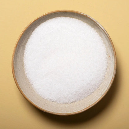 Fine sea salt mineral crystals from Whole Food Earth, showing the textured, white salt grains on a neutral background.