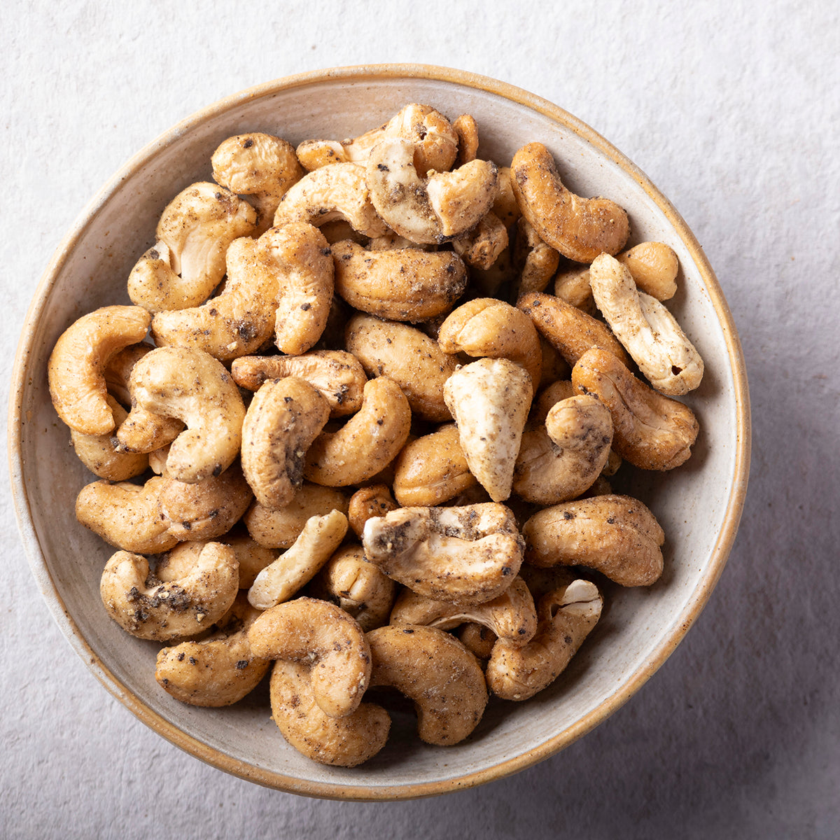 Whole Food Earth sea salt and black pepper baked cashews, crunchy nuts with flavorful seasoning, in a close-up view.
