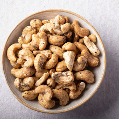 Whole Food Earth sea salt and black pepper baked cashews, crunchy nuts with flavorful seasoning, in a close-up view.