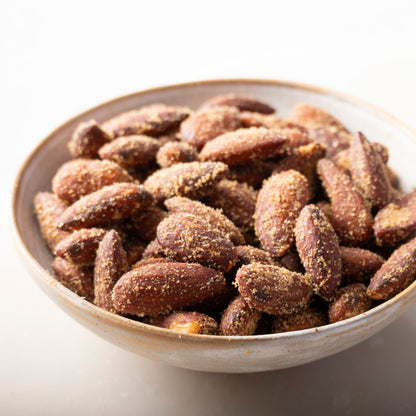 Bowl of smoked seasoned baked almonds from Whole Food Earth, displaying crispy, flavorful nuts with smoky seasoning.