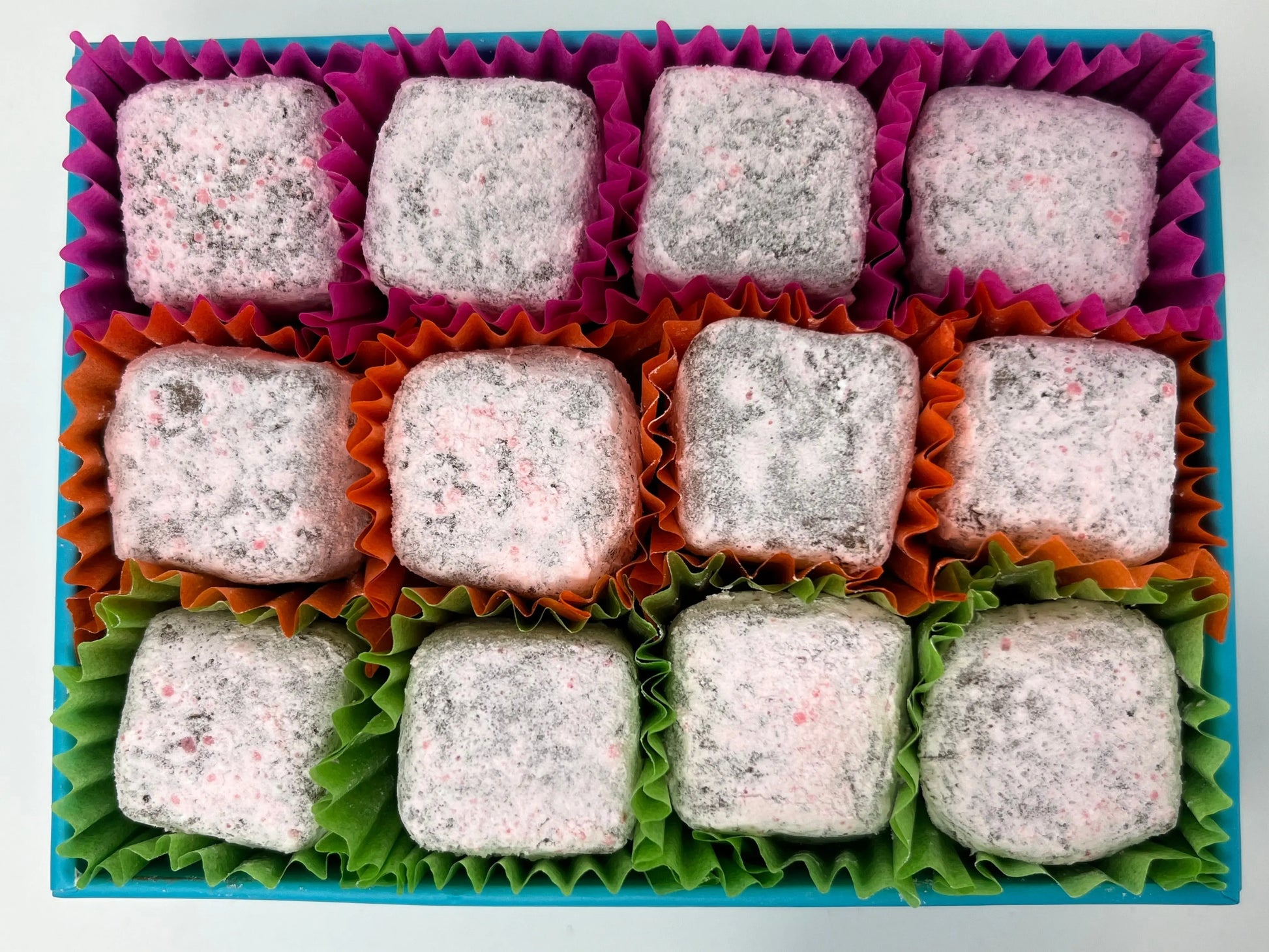 Gorvett & Stone Strawberry Gin Fizz truffles with pink coating and decorative toppings, showcasing a luxurious chocolate treat.