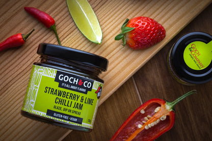 Glassy jar of Goch & Co Strawberry & Lime Chilli Jam with fresh strawberries and lime slices on the label.