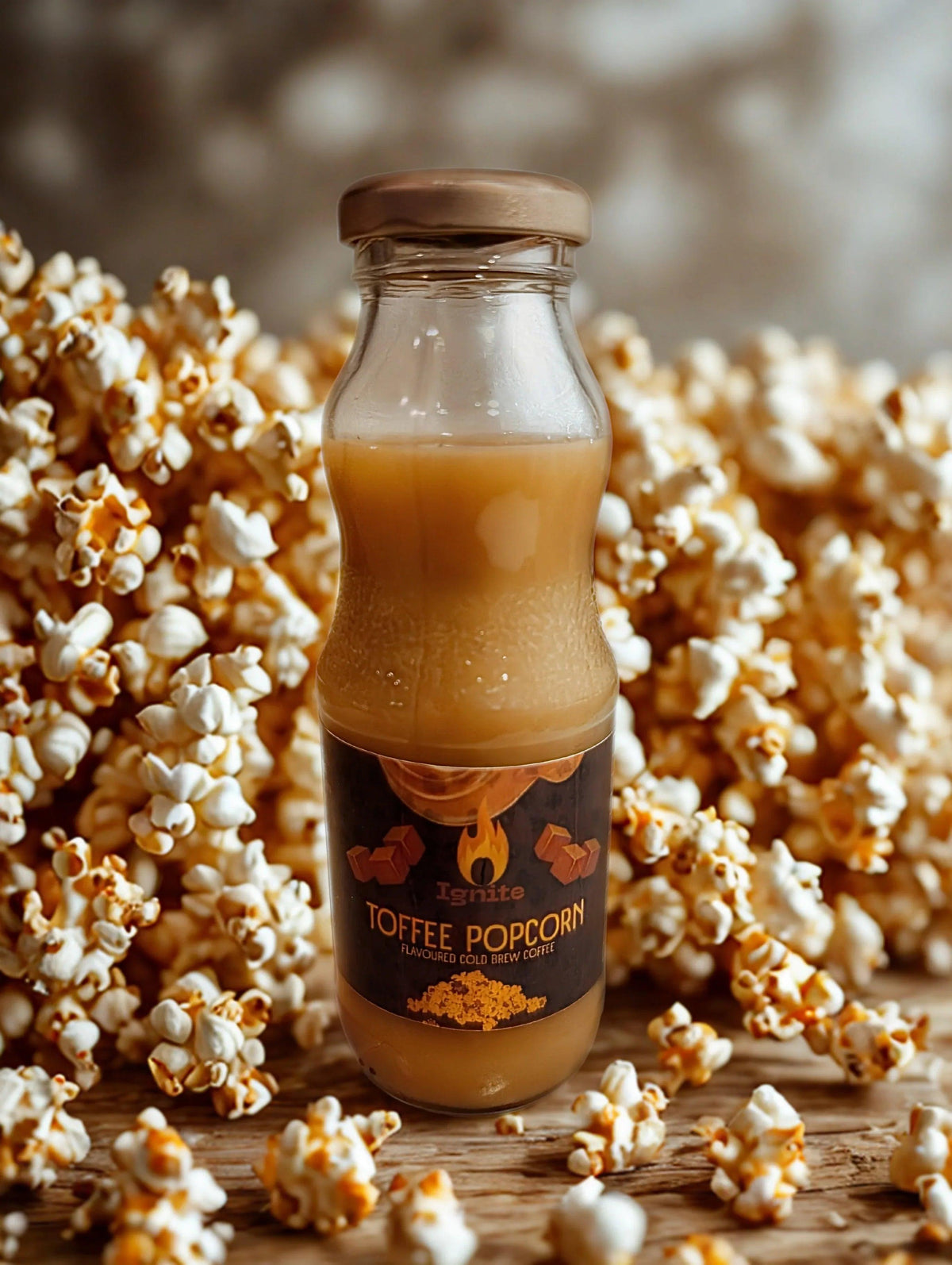 Cold brew coffee with toffee popcorn flavor from Ignite Coffee Co, served in a glass with frothy top and caramel drizzle.