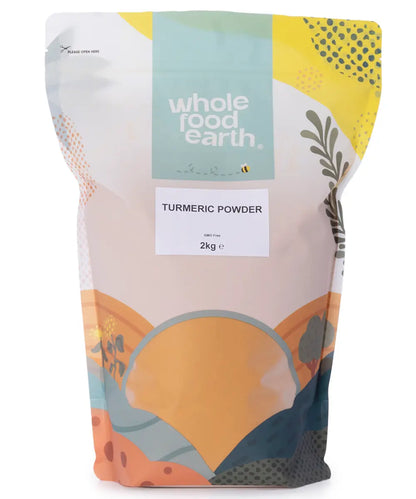Two kilograms of bright yellow turmeric powder from Whole Food Earth, displayed in a clear jar on a wooden surface.