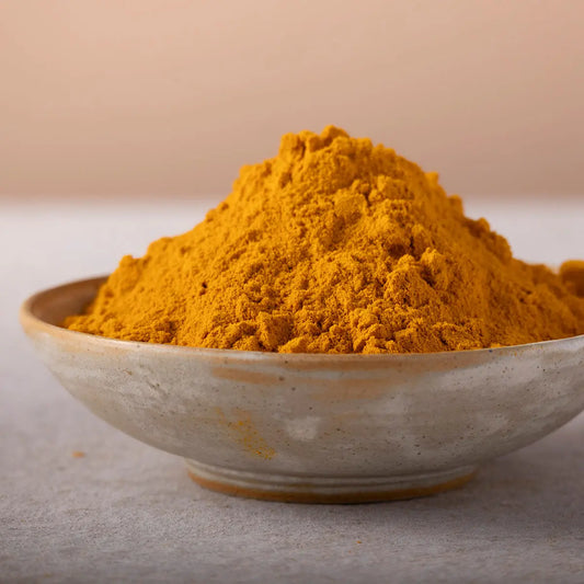 Bright yellow turmeric powder in a glass jar, showcasing Whole Food Earth herbs and spices collection.