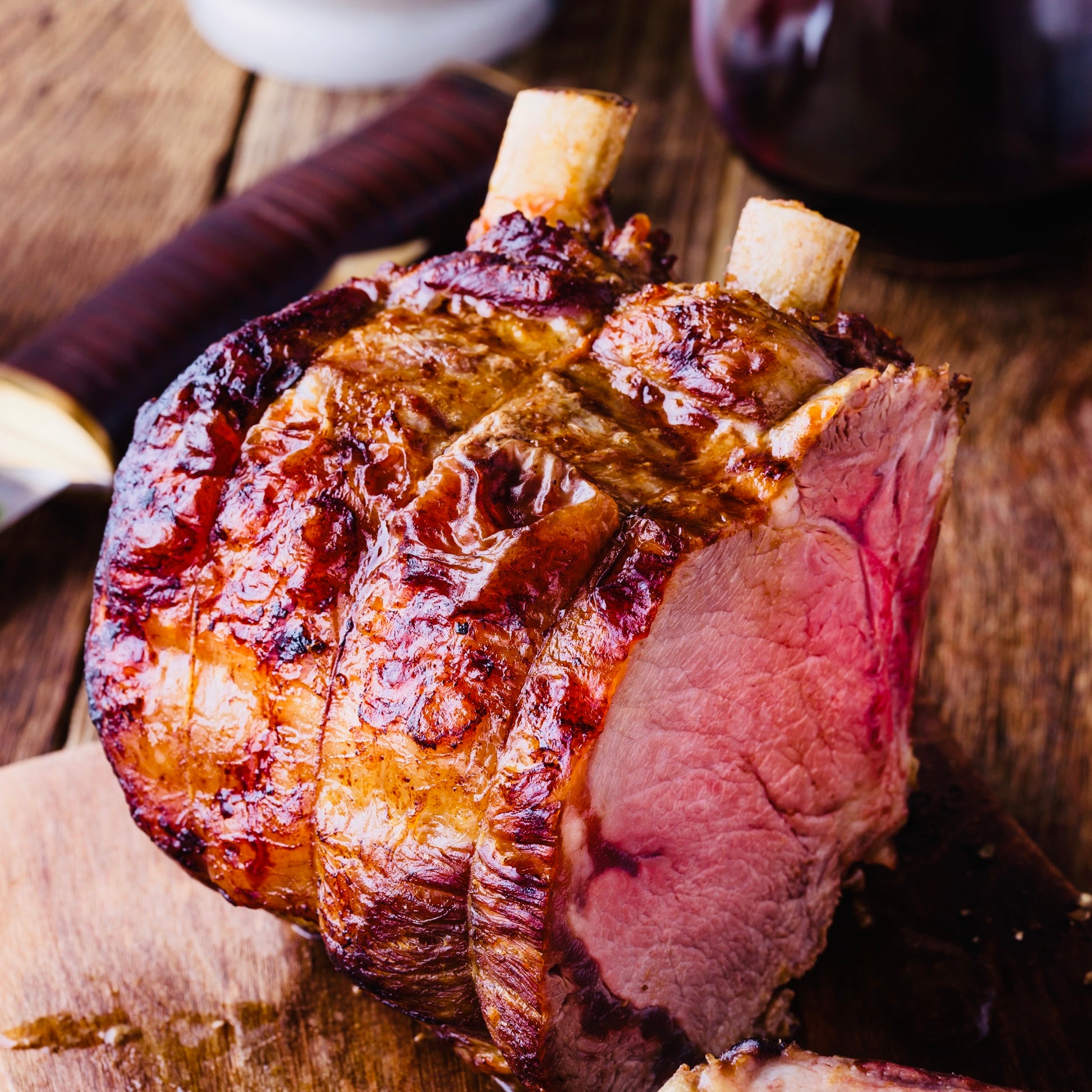 Prime Primrose Herd dry-aged bone-in beef rib joint, French-trimmed, showcasing rich marbling and expertly prepared beef cut.