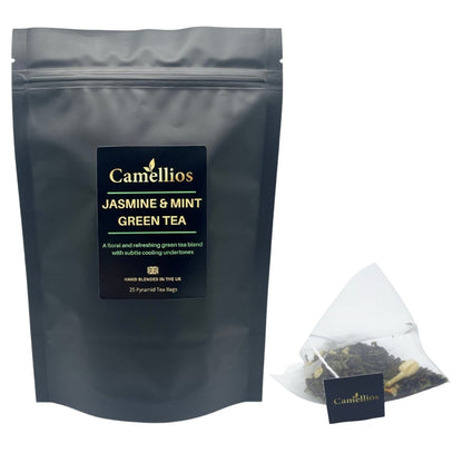 Camellios Jasmine and Mint Green Tea in a clear glass cup with tea leaves and fresh mint leaves, showcasing a soothing herbal infusion.