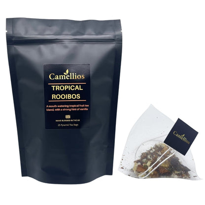 Camellios Tropical Rooibos tea in a glass cup with vibrant tropical fruits and leaves, showcasing a colorful tea infusion.