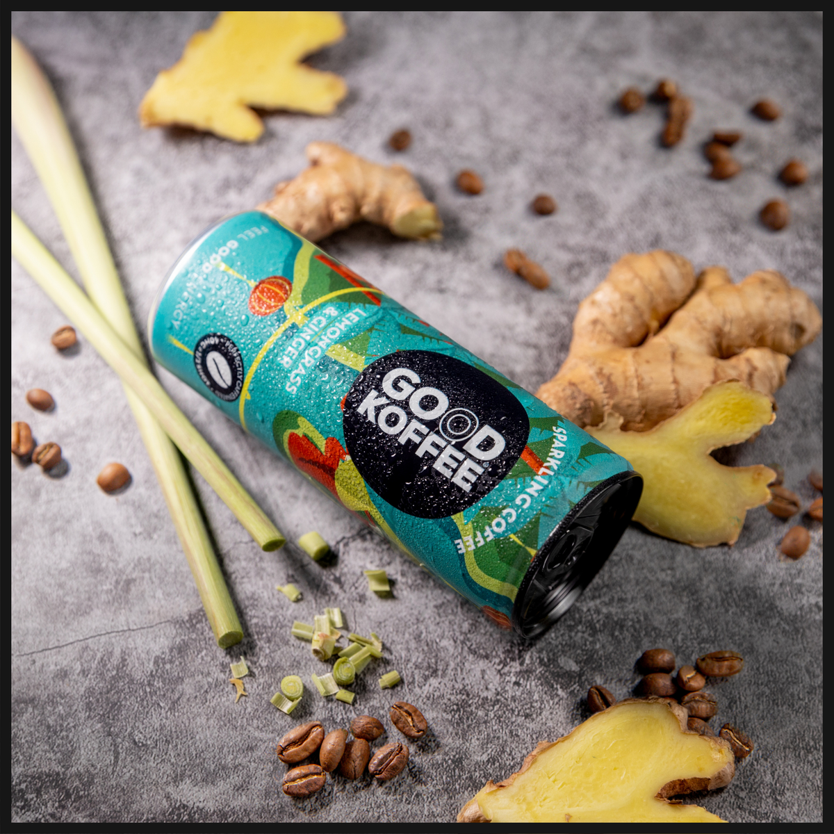 GOOD KOFFEE Vietnam Lemongrass & Ginger sparkling coffee 12-pack on a grey background with fresh ginger, lemongrass and coffee beans.