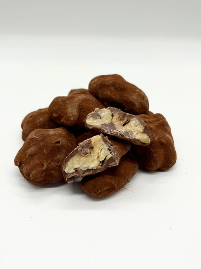 Gorvett & Stone milk chocolate-covered walnuts, showing glossy chocolate coating and whole walnuts inside.