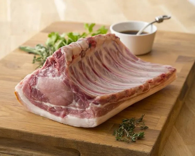 Whole bone-in pork loin from Primrose Herd, showing fresh, pink pork loin with bone, ready for cooking.