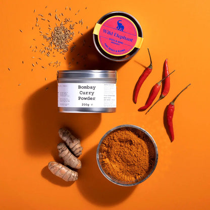 Wild Elephant Bombay Curry Powder from Whole Food Earth, a blend of spices in a colorful jar, ideal for flavorful Indian dishes.