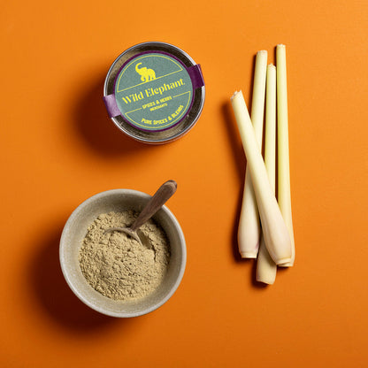 Organic ground lemongrass from Wild Elephant, a natural herb and spice, shown in a 50g package with fresh, green ground lemongrass.