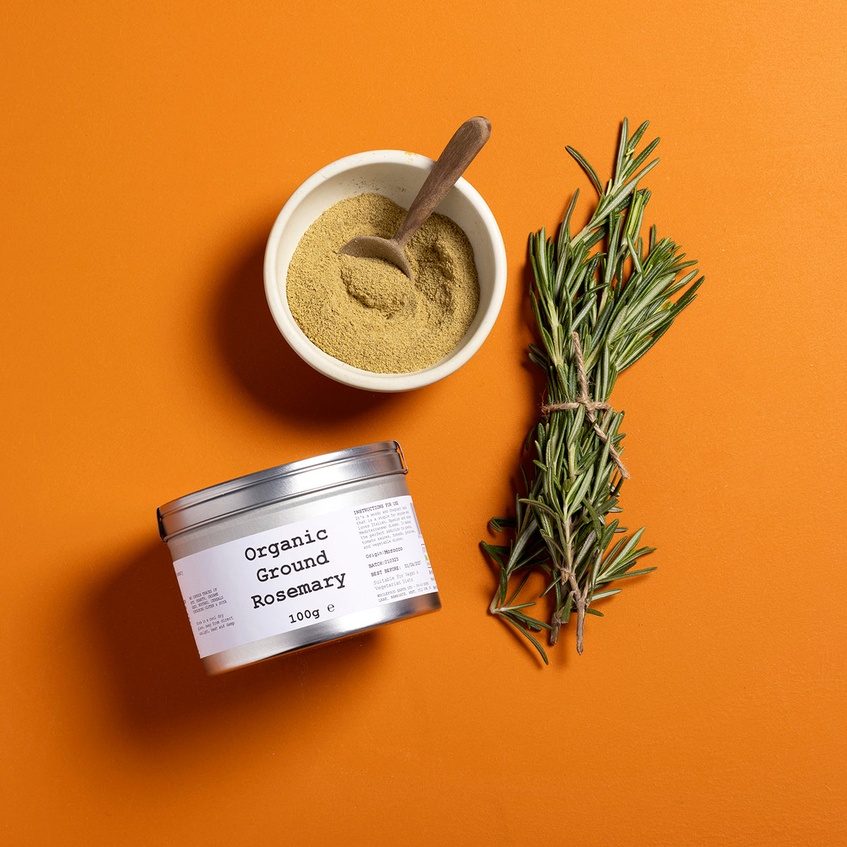 Organic ground rosemary from Wild Elephant, a Whole Food Earth herb spice in a 100g package, shown in a clear jar with fresh rosemary sprigs.