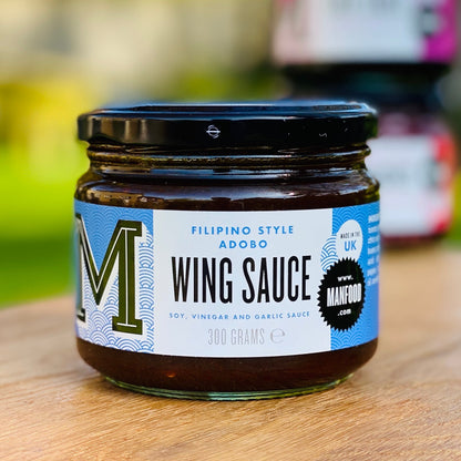 Manfood Adobo Wing Sauce in a bottle, rich and flavorful sauce ideal for wings and grilled dishes, with a dark, glossy appearance.