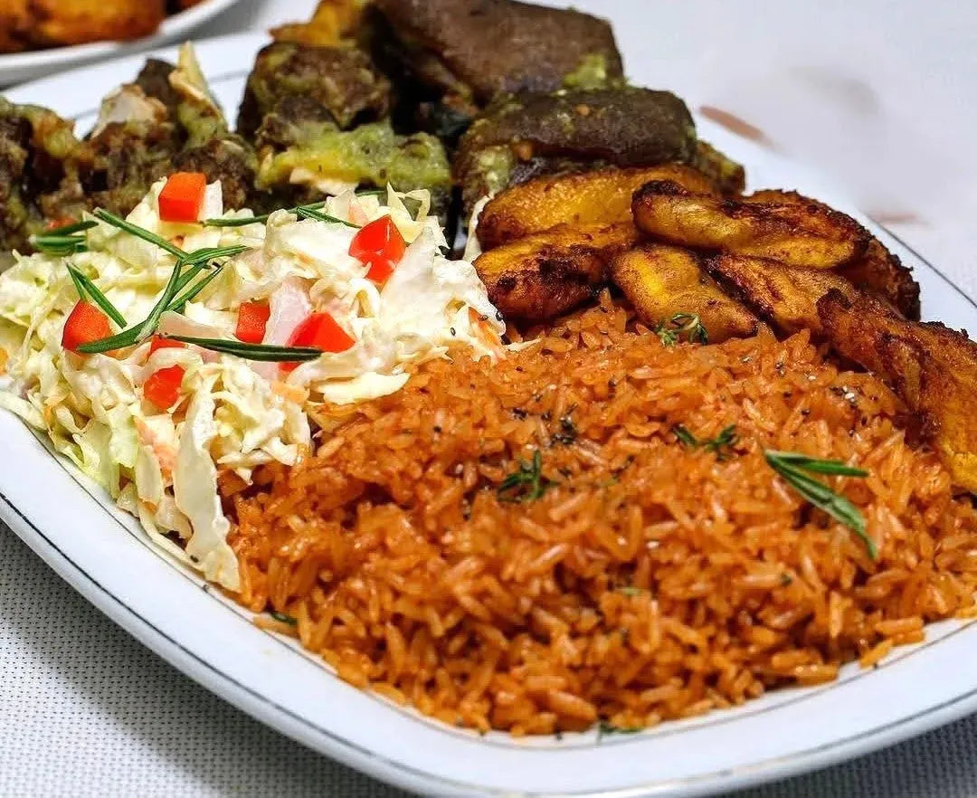 Ntriwaa Catering beef jollof rice dish with rich, flavorful Ghanaian sauce, served on a plate with garnishes, highlighting authentic taste.