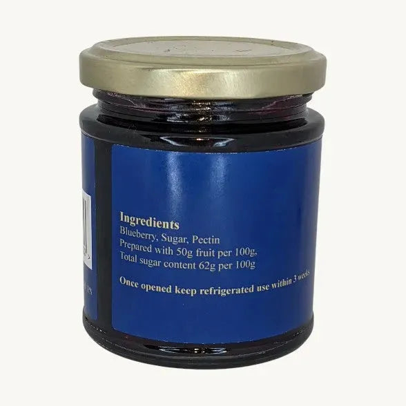 Close-up of Friars Farm Blueberry Jam 200g jar with a spoon, showcasing the rich, purple-blue jam and fresh blueberries.