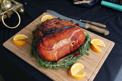 Cooked bone-in Gammon joint from Primrose Herd, showcasing a juicy, tender ham with visible bone and a glistening glaze.