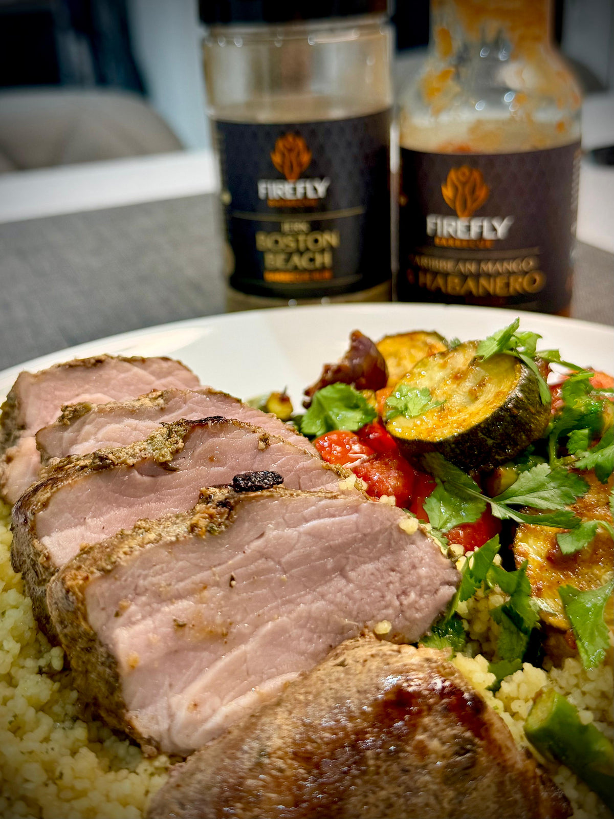 FireFly Barbecue Boston Beach Jerk Rub on lamb, showcasing a flavorful BBQ spice blend in a jar.